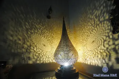 a lamp sitting on a table in front of a wall at Riad Mama H&K in Meknès