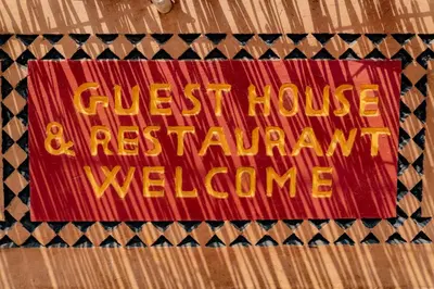 a sign for a guest house and a restaurant welcome at Kasbah La Datte D'or in Skoura
