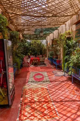 a patio with a table and a patterned rug at Kasbah La Datte D'or in Skoura