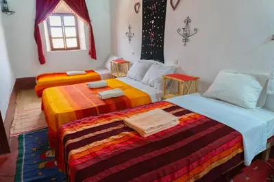 two beds sitting in a room with a window at Kasbah La Datte D'or in Skoura