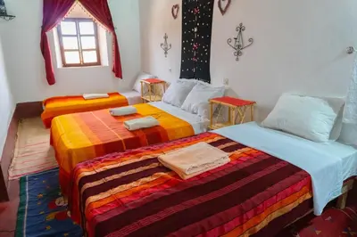 a bedroom with two beds with colorful blankets at Kasbah La Datte D'or in Skoura