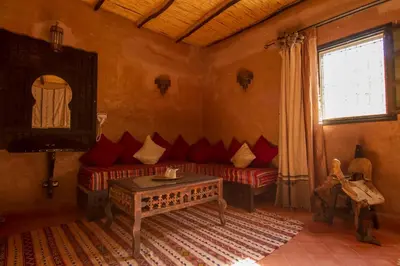 a living room with a red couch and a window at Rose Noire in Ouarzazate