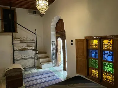 a room with a staircase and a door with stained glass at Dar Rbab in Fès