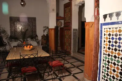 a room with a table with chairs and a bowl of fruit at Dar Rbab in Fès