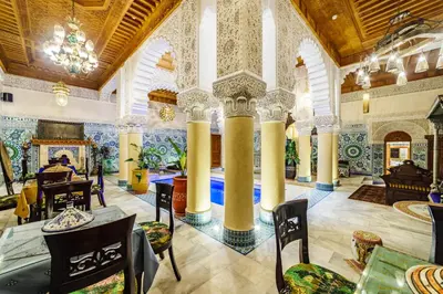 a large room with columns and tables and chairs at Riad Rcif & Spa Originale in Fès