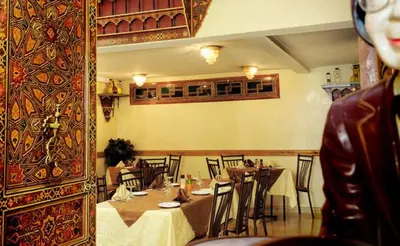 a restaurant with tables and chairs in a room at Perla Hôtel in Fès