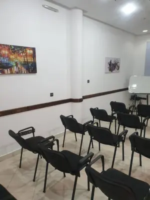 a room with chairs and a painting on the wall at Perla Hôtel in Fès