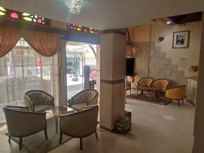 a waiting room with chairs and a table and a window at Perla Hôtel in Fès