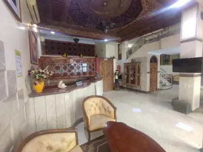 a living room with two chairs and a bar at Perla Hôtel in Fès