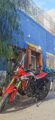 a motorcycle parked in front of a blue building at Atlas Room in Midelt