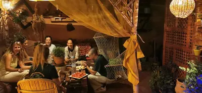 a group of people sitting at a table in a restaurant at Atlas Room in Midelt