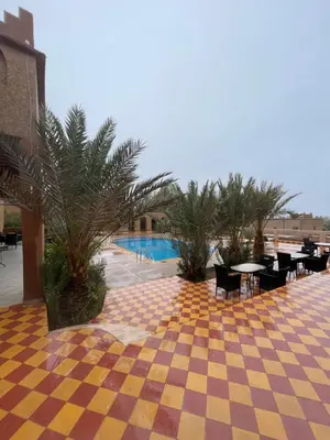 a resort with a checkered floor and tables and chairs at Auberge Famille Benmoro in Skoura