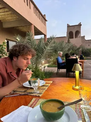 a man sitting at a table eating a bowl of soup at Auberge Famille Benmoro in Skoura
