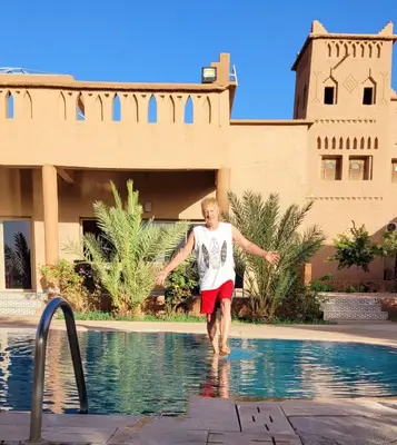 a man walking in the water in a swimming pool at Auberge Famille Benmoro in Skoura