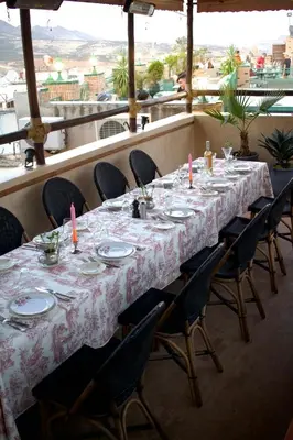 a long table with chairs and plates and candles on it at Riad Anata in Fès