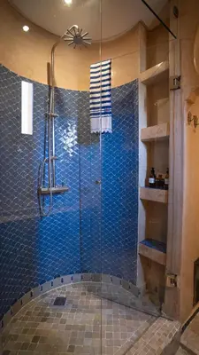 a bathroom with a shower with blue tiles at Riad Anata in Fès