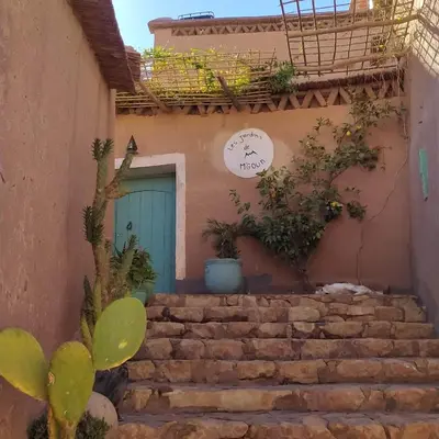 a building with a blue door and some stairs at Les Jardins du M'goun in Kalaat MGouna