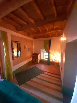 a living room with a bed and a rug at Les Jardins du M'goun in Kalaat MGouna