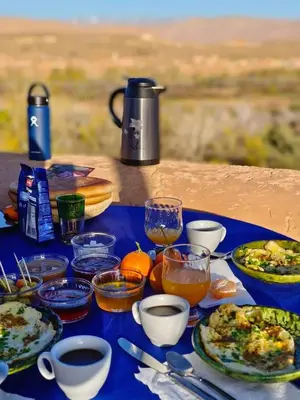 a table with plates of food and drinks on it at Les Jardins du M'goun in Kalaat MGouna