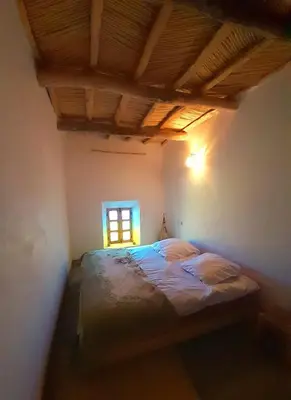 a bedroom with a bed in a room with a window at Les Jardins du M'goun in Kalaat MGouna