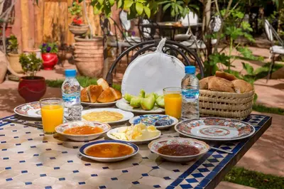 a table with plates of food and drinks on it at Hôtel Chellal ďOuzoud in Ouzoud