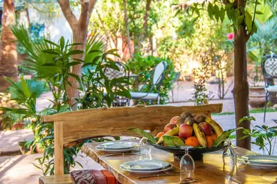 a wooden table with a bowl of fruit on it at Hôtel Chellal ďOuzoud in Ouzoud