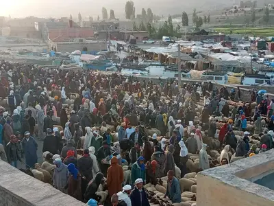 a large crowd of people standing in a market at Auberge des lacs in Imilchil