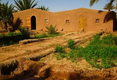 a building in the middle of a dirt road at Chez Madani in Mhamid