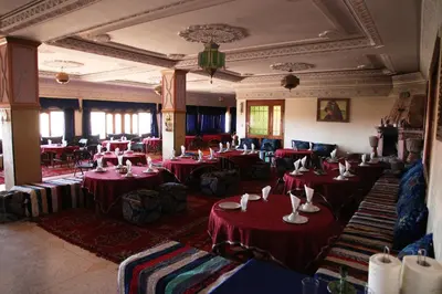 a dining room with red tables and chairs at La Kasbah De Dades in Boumalne
