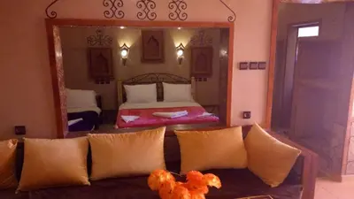 a living room with a couch in front of a bedroom at La Kasbah De Dades in Boumalne