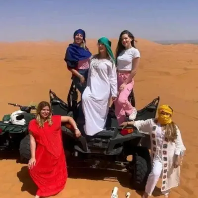 a group of women standing on a jeep in the desert at Les Pyramides Luxury desert Camp in Merzouga