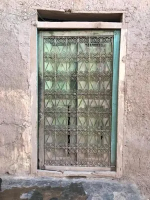 a window with an iron grate on a building at Écologie oasis tafilalt CHEZ L' HABITANT in Er Rachidia