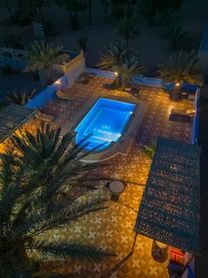 an overhead view of a swimming pool at night at Auberge Les Roches in Merzouga