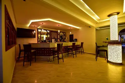 a restaurant with a bar with chairs and a table at Hôtel Fès Inn & SPA in Fès
