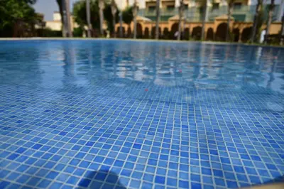 a swimming pool with blue tiles on it at Hôtel Fès Inn & SPA in Fès