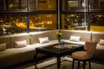 a room with a couch with a table and chairs at Palais Ommeyad Suites & Spa in Fès