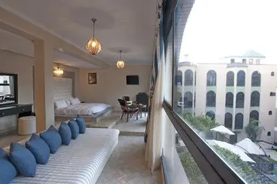 a bedroom with a bed with blue pillows on it at Palais Ommeyad Suites & Spa in Fès