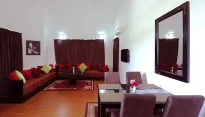 a living room with a red couch and a table at Farah Inn Ifrane in Ifrane