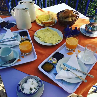 a table with plates of food and drinks on it at Auberge le Maquis in Aghbalou