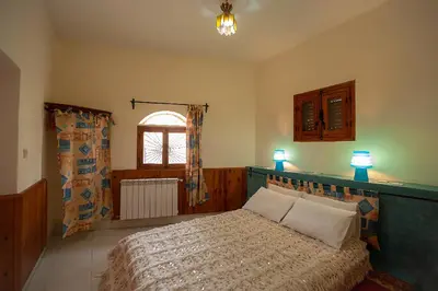 a bedroom with a bed with two pillows and a window at Auberge le Maquis in Aghbalou