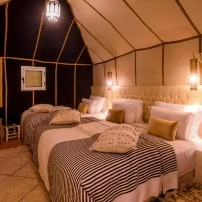a bedroom with two beds in a tent at Magic Luxury Camp in Merzouga
