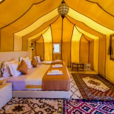 a bedroom with a bed in a tent at Magic Luxury Camp in Merzouga