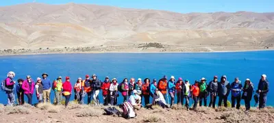 a group of people standing in front of a lake at Complexe Collier D' Ambre in Imilchil