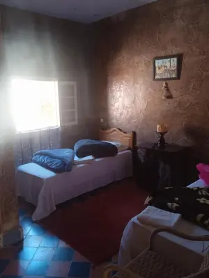 a room with two beds and a window and a room with at Complexe Collier D' Ambre in Imilchil