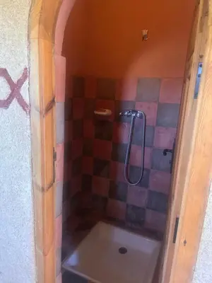 a bathroom with a shower with a tile wall at Auberge Des Jardins du Dades in Boumalne