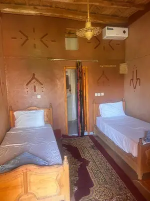 a bedroom with two beds in a room at Auberge Des Jardins du Dades in Boumalne