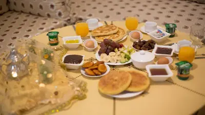 a table topped with breakfast foods and orange juice at Dar Dahab in Fès