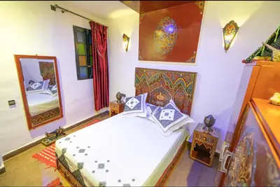 a bedroom with a white bed and a mirror at Dar Dahab in Fès