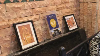 a group of framed pictures on a stone wall at Dar Pa Labzioui in Meknès