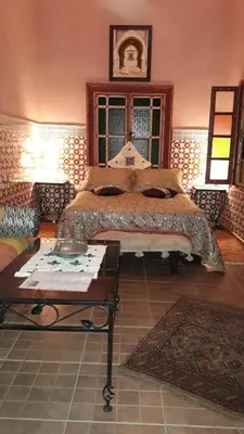 a bedroom with a bed and a table in it at Dar Pa Labzioui in Meknès